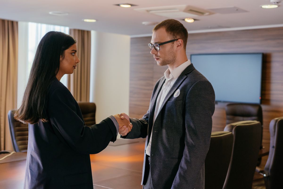 Two professionals shaking hands at the start of a job interview