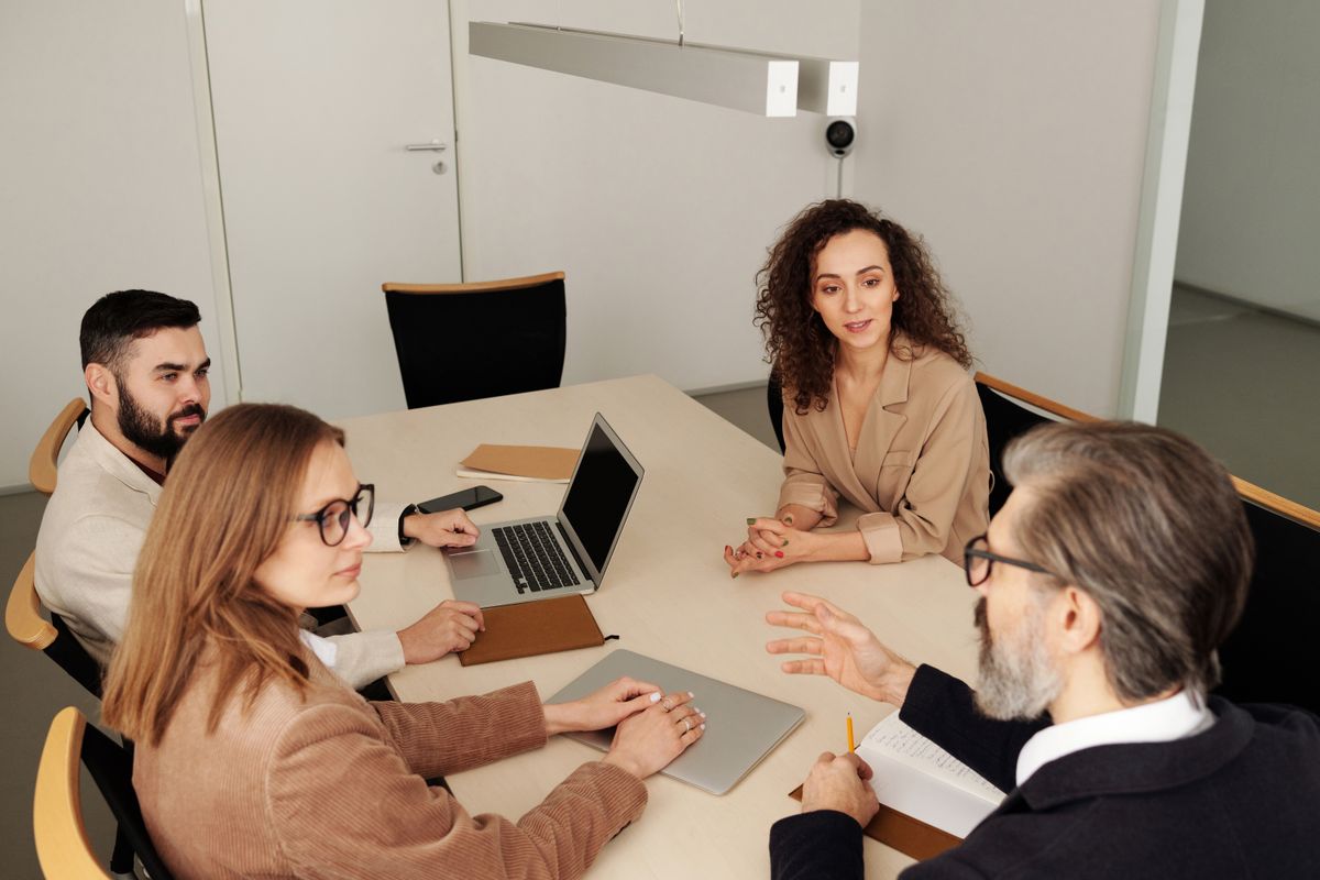 A professional leading a team discussion around a conference table
