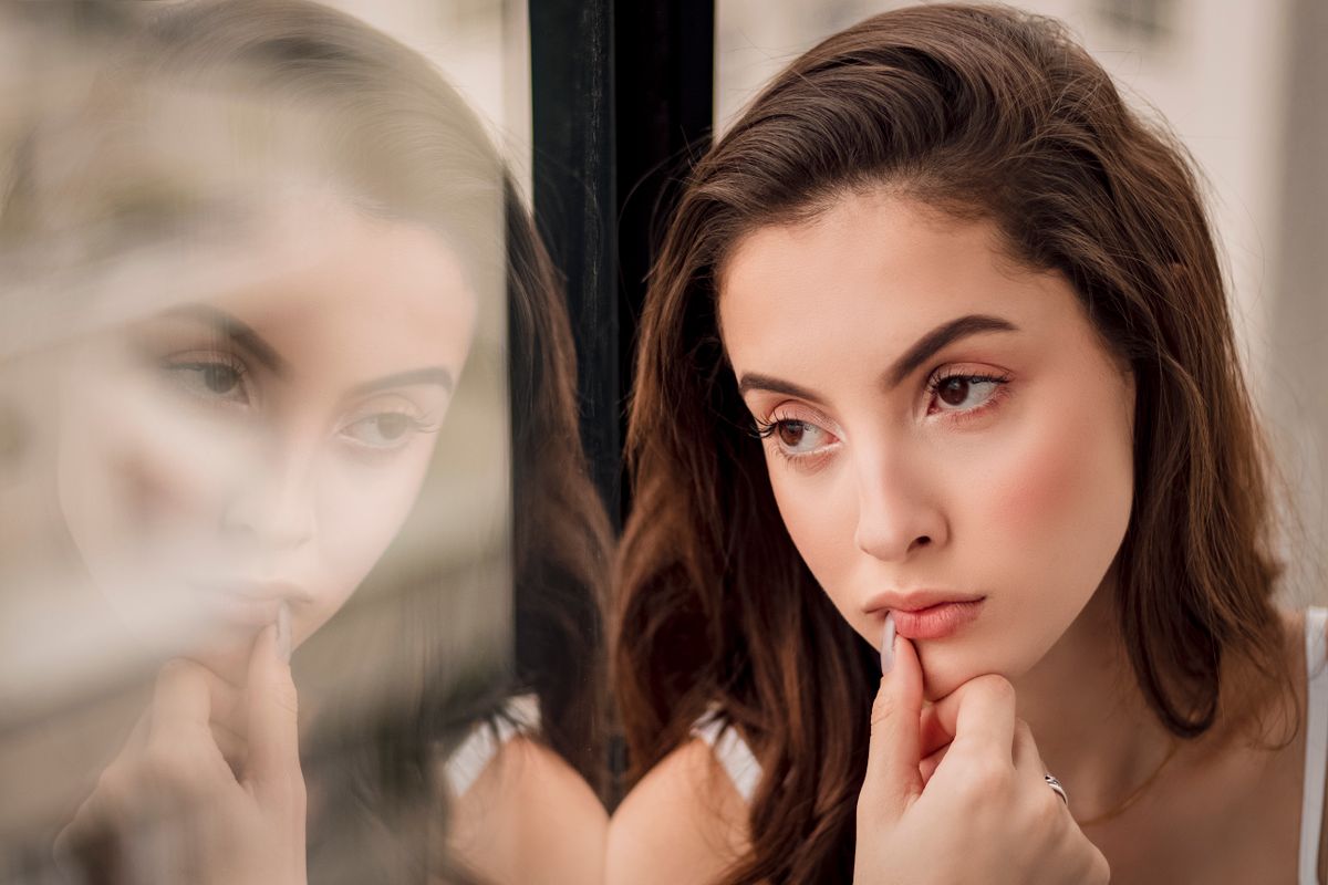 A woman looking out a window in quiet reflection